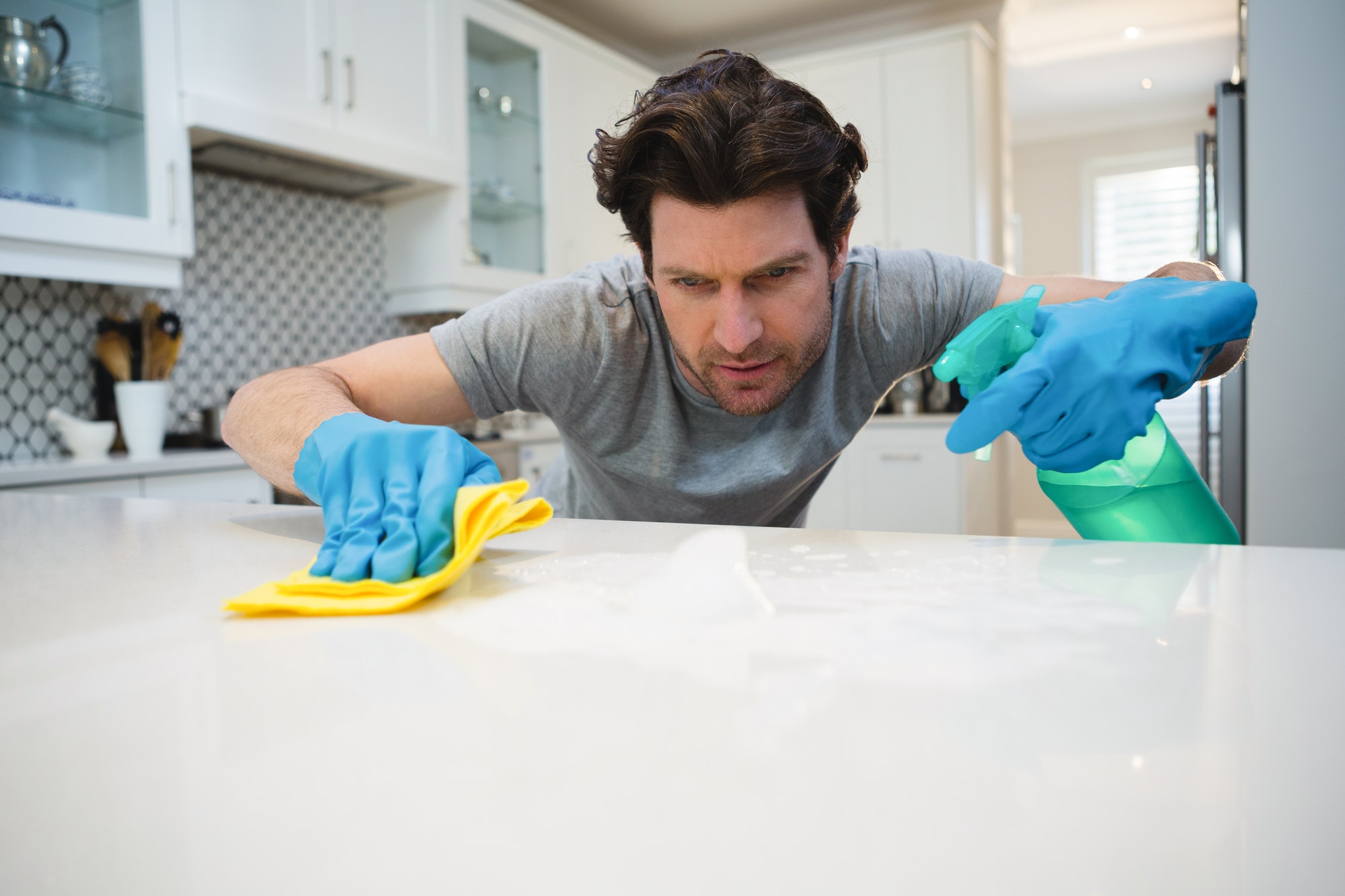man-cleaning-kitchen-worktop-at-home.jpg